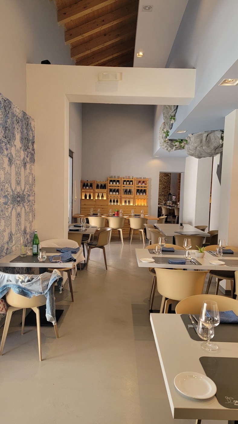 La sala luminosa con soffitto in legno e la parete dei vini